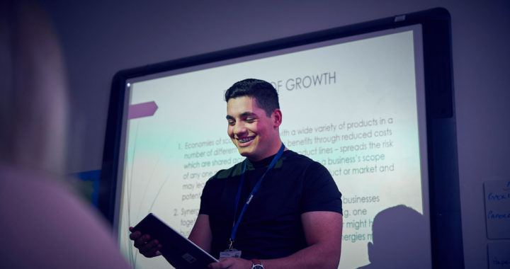 A Sunderland College business studnet delivering a presentation in front of a projector