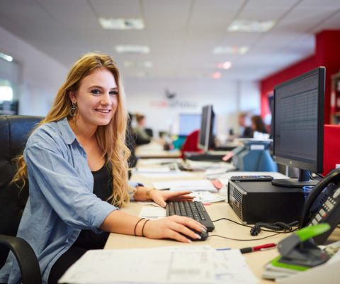 An accounting student on an apprenticeship, smiling at the camera