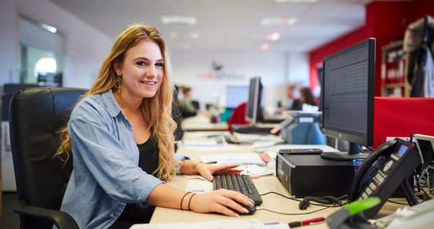 An accounting student on an apprenticeship, smiling at the camera